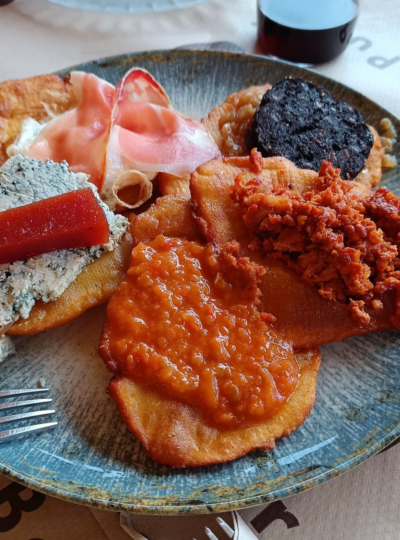 Tortos asturianos recién hechos - Comida tradicional típica de Asturias servida en tabla de madera con picadillo, huevo y queso