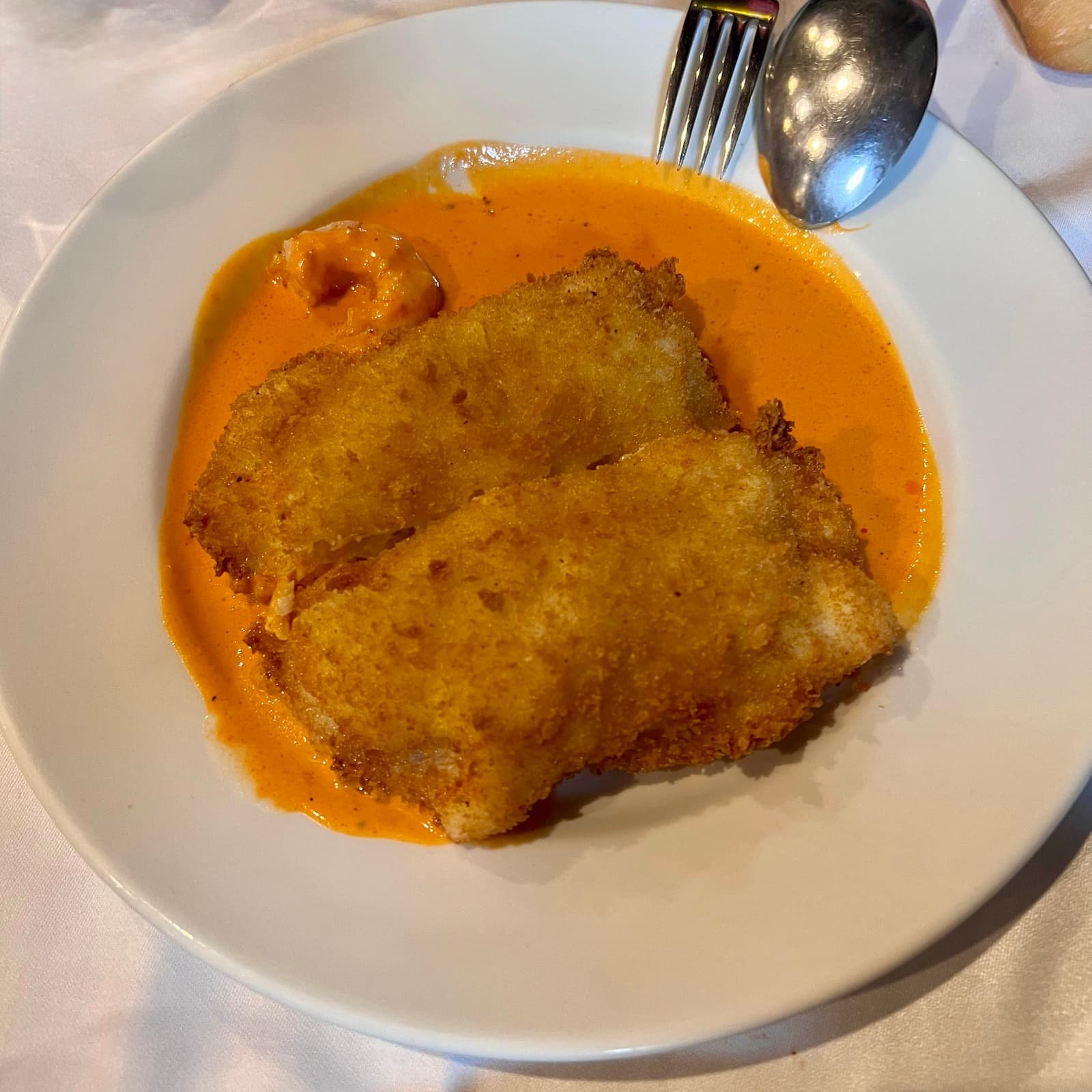 Platos típicos de Asturias servidos en una mesa tradicional asturiana, el cachopo de pescado, un imprescindible en tu guía de platos típicos que tienes que probar en Asturias