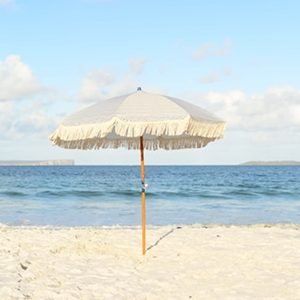 Turistas con una sombrilla en la playa, disfrutando Asturias