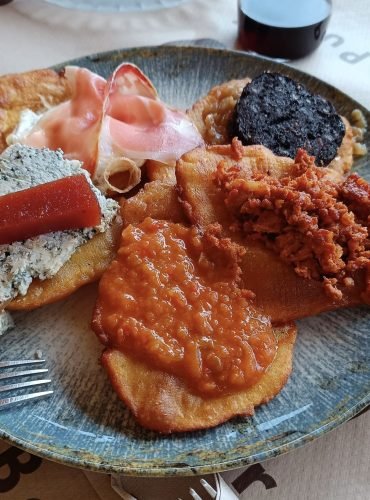 Tortos asturianos recién hechos - Comida tradicional de Asturias servida en tabla de madera con picadillo, huevo y queso